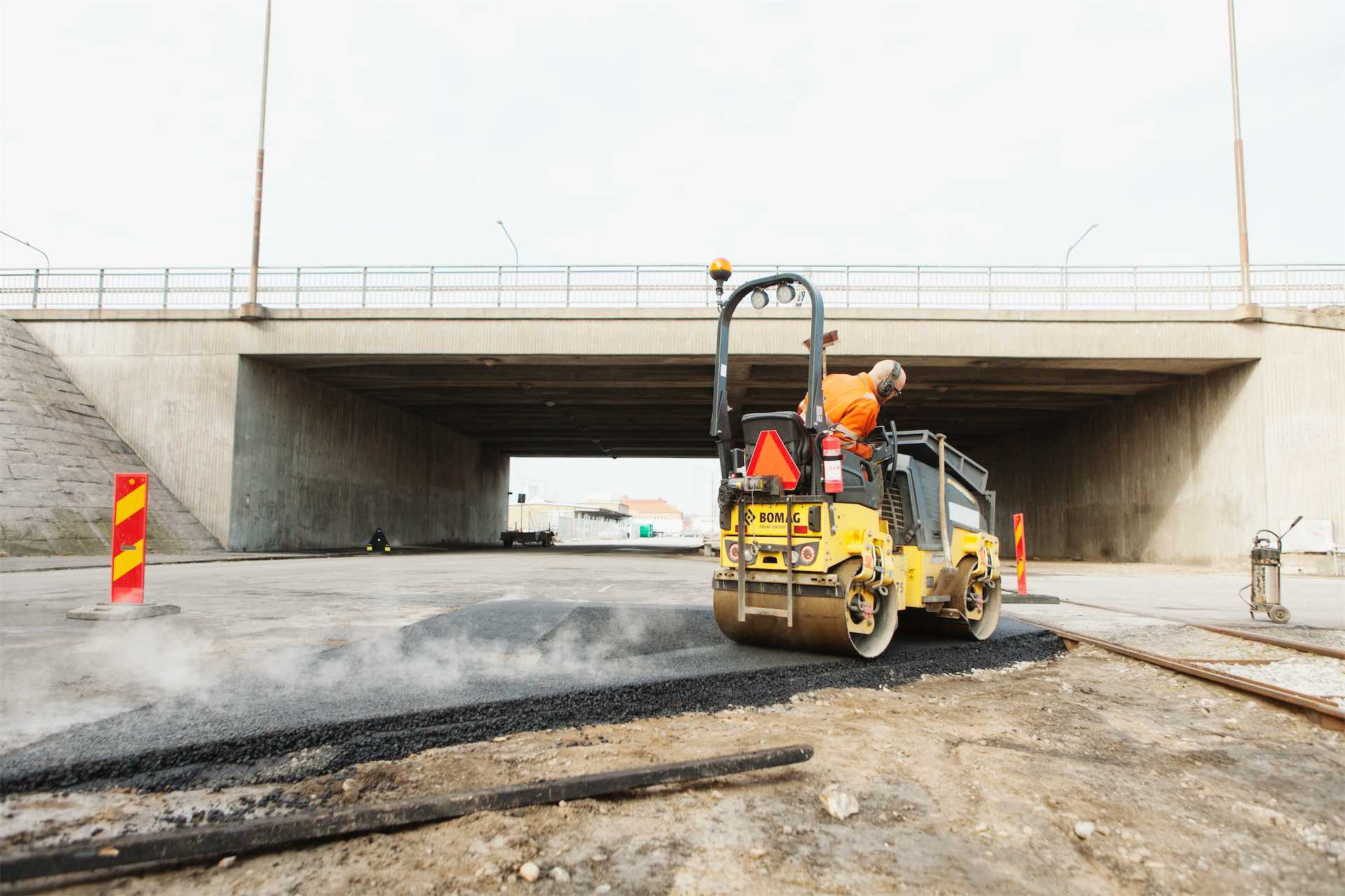 worker-paving-a-new-road-under-an-overpass-2026-01-09-10-20-32-utc